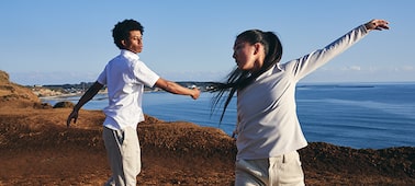 Example image of a man and woman dancing with the sea in the background