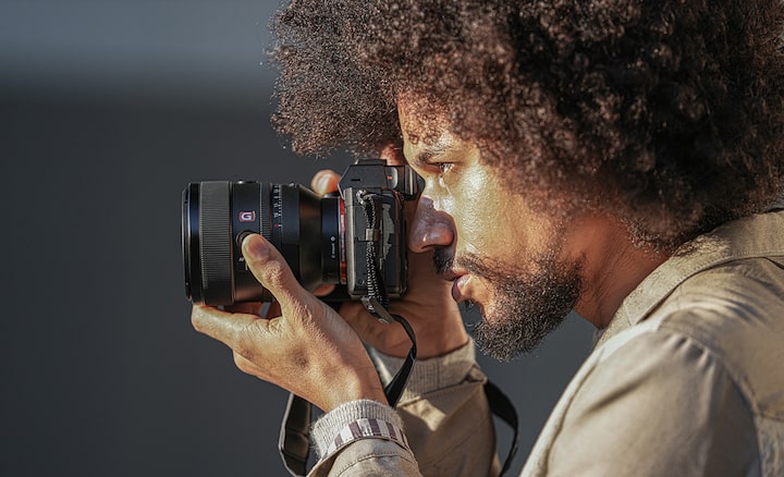 Image of a person holding a camera with the FE 50mm F1.2 GM lens attached