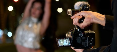 Usage image of a videographer’s arms holding the FX2 and filming a woman dancing in the bokeh background