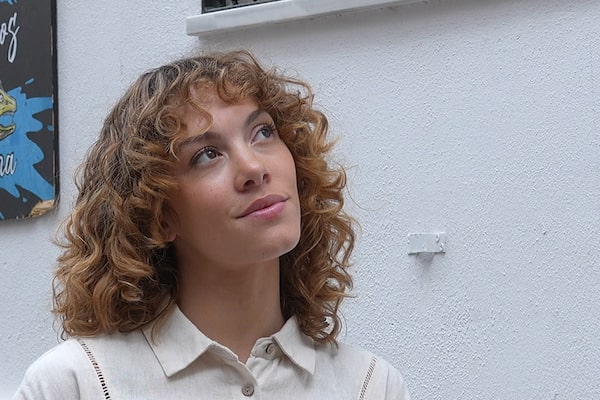 Example image showing half-profile portrait of a woman in front of a white wall with a painting