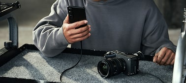 Usage image of the FX2 connected to a smartphone via a USB cable, transferring recorded video