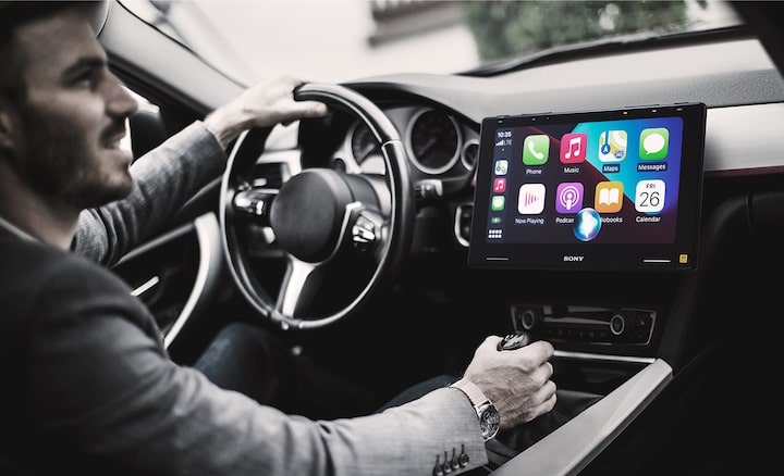 The 10.1" (25.7cm) Mobile ES™ High-Resolution Digital Media Receiver seen in-situ on a car dashboard, with Apple Car Play on the screen.