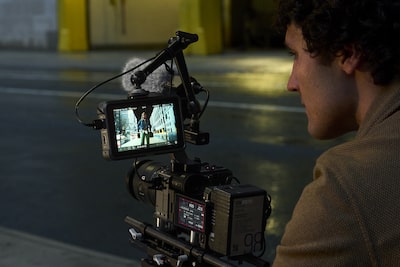 Usage image showing a videographer operating the FX2 with an HDMI cable connected and outputting video to an external recorder