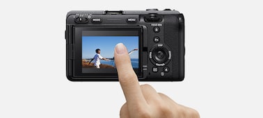 Usage image of a finger touching the camera’s LCD screen, showing the touch focus function
